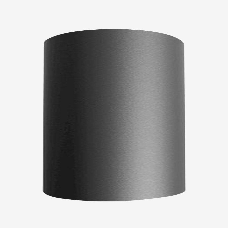 A black cylinder lamp shade on a white wall.